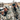 Man and woman in matching GameGuard camo jackets spotting game in a snowy field.