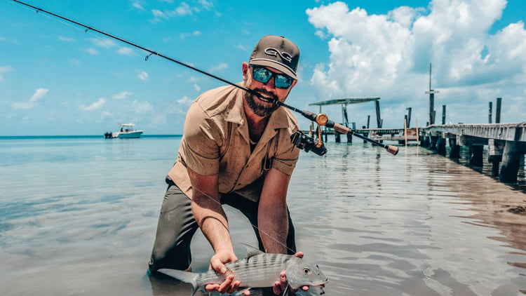 CAMP SHIRT. Man wears GameGuard Camp Shirt with classic collar and chest pocket, paired with MeshBack Cap. Lightweight shirt, UPF 30+, coconut buttons, breathable outdoor shirt, summer hiking shirt, casual fishing shirt, wrinkle-resistant travel shirt.