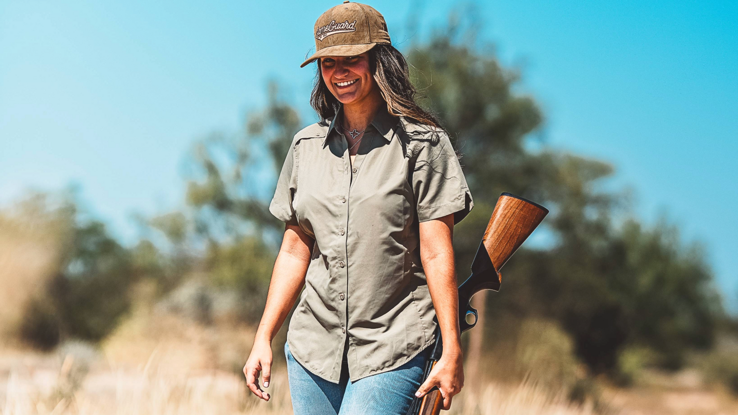 LADIES' SHIRTS. Woman walks with shotgun wearing GameGuard Ladies’ Original Shirt and Corduroy Cap. Women’s outdoor shirt, UPF 50+, vented, moisture-wicking, flattering fit, field-tested women’s hunting shirt, ranchwear for her, GameGuard ladies’ apparel.