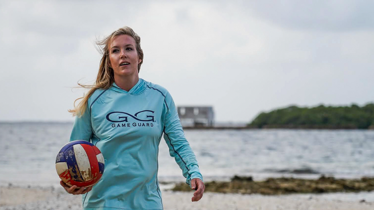 LADIES' PERFORMANCE. Woman plays volleyball on the beach in GameGuard Ladies’ Defender Hoody. Women’s sun shirt, UPF 30+, moisture-wicking, quick-dry, breathable activewear, outdoor hoody, performance fishing apparel, GameGuard for her, athletic layer.