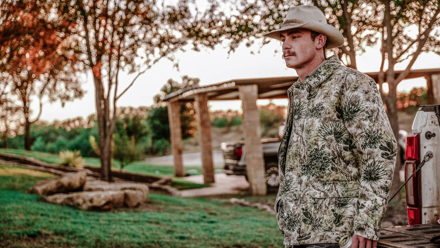 LIMITED EDITION. Cowboy wears exclusive camo GameGuard Barn Jacket. Limited edition camo outerwear, western hunting jacket, water-resistant, windproof, field-tested gear, GameGuard exclusive apparel, ranch-ready jacket, collector outdoor wear.