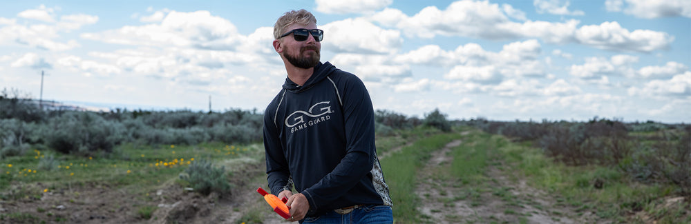 man wearing black caviar performance hoody tossing clay lightweight and sun protection