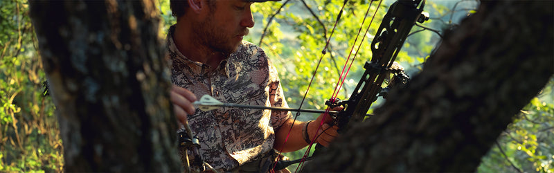 Man bow hunting in the woods wearing GameGuard Digital Camo Explorer Shirt