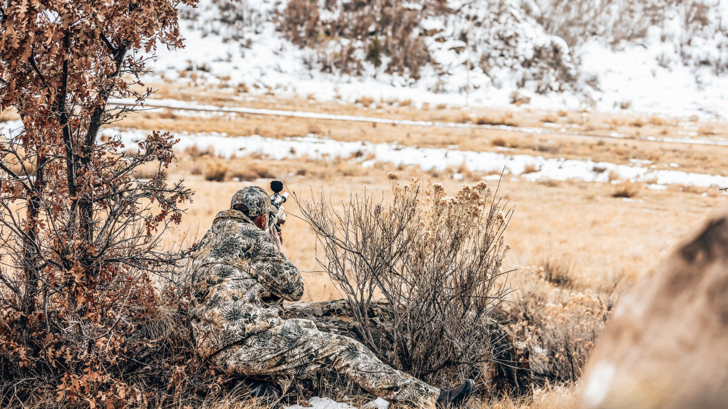 HUNTING. Hunter aims from prone position in full GameGuard Digital camo—Guía Grande Jacket, Pants, and Cap. Concealment hunting gear, waterproof camo, windproof jacket, rifle-ready apparel, rugged outerwear, performance hunting layers, snow-season camo.