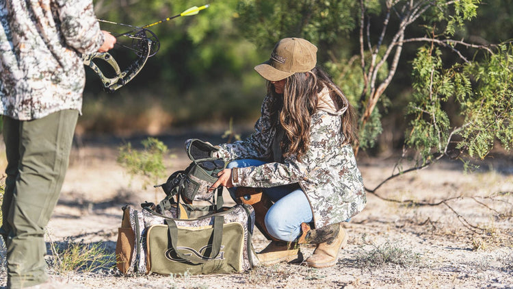 FIELD GEAR. Hunters wear GameGuard Digital camo while packing GameGuard Accessory Bag and Bino Case. Camo field gear, hunting bags, durable outdoor accessories, archery apparel, rugged camo jacket, GameGuard Digital camo duffle, field-tested gear.