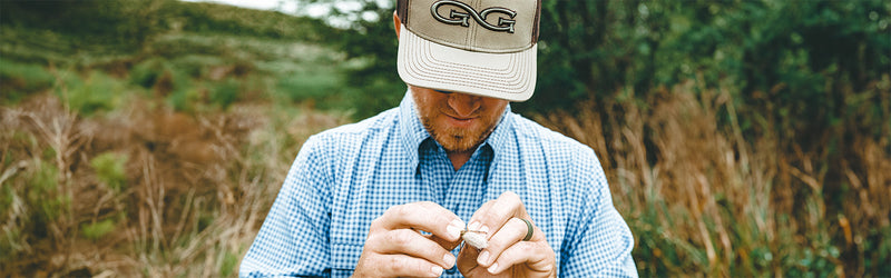 Man using fishing lure wearing GameGuard TekCheck shirt in the wild.