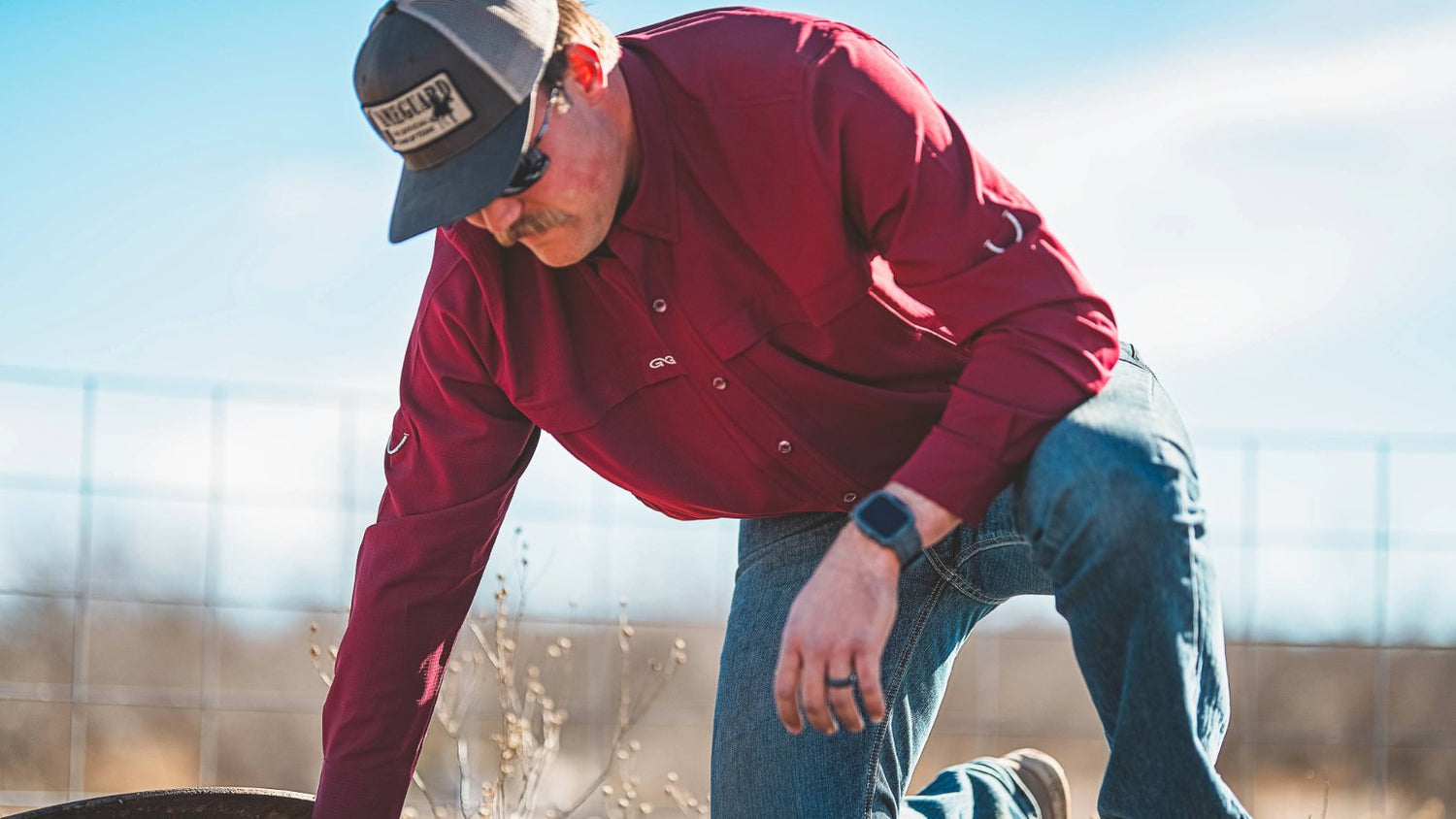 SCOUT SHIRT. Man works outdoors in GameGuard Scout Shirt, designed for versatility and movement. Ranch-ready shirt, mechanical stretch, UPF 50+, moisture-wicking, vented back, durable long sleeve shirt, GameGuard work shirt, rugged field-tested apparel.