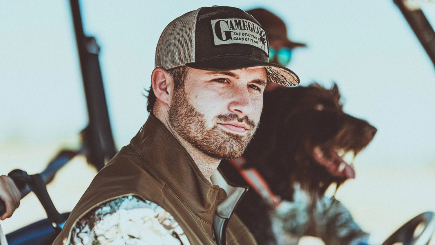 PATCH CAPS. Man wears GameGuard Patch Cap with “Official Camo of Texas” text and GameGuard Digital bill. MeshBack patch hat, outdoor lifestyle cap, camo brim cap, western trucker hat, breathable snapback, GameGuard branded headwear, rugged hunting cap.