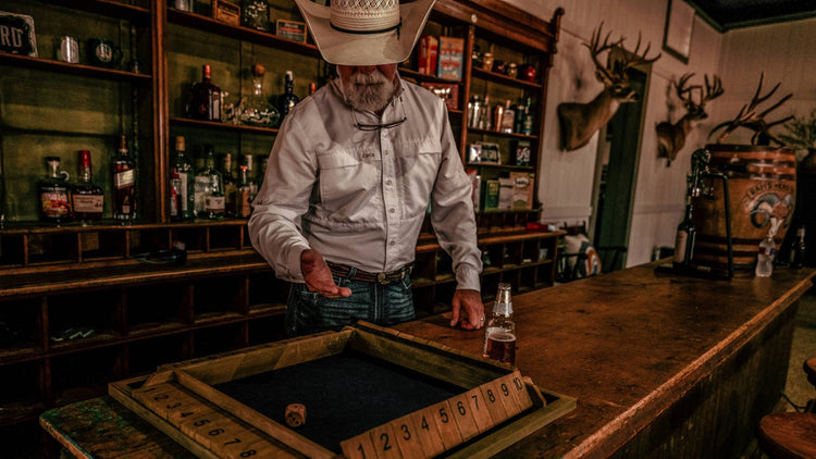 BEST SELLERS. Cowboy in GameGuard Original Shirt plays bar game in rustic saloon. GameGuard best selling outdoor shirt, moisture-wicking, UPF 50+ sun protection, wrinkle-resistant, quick-dry performance shirt, western lifestyle apparel, hunting shirt.