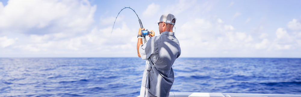 man deep sea fishing in button down microtek shirt