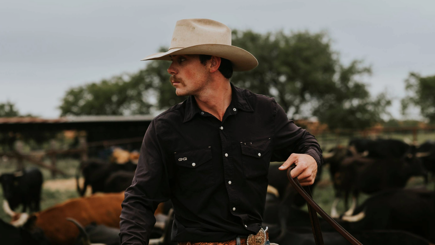 STOCKYARD SHIRT. Cowboy ropes on horseback in GameGuard StockYard Shirt with western yoke and faux horn pearl snaps. Rugged ranch shirt, UPF 50+, mechanical stretch, stain-resistant, durable outdoor workwear, cowboy apparel, GameGuard western classic fit.