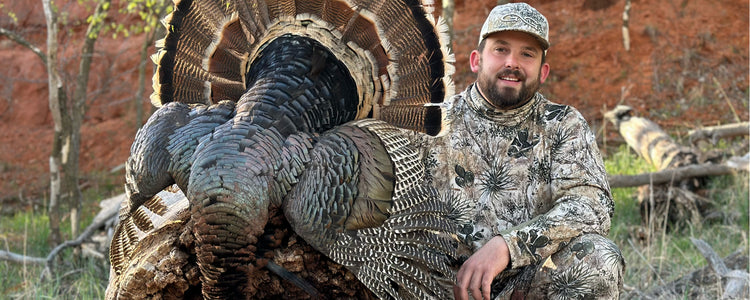 Man kneeling with turkey wearing GameGuard cap and GameGuard Relaxed MicroFiber Shirt