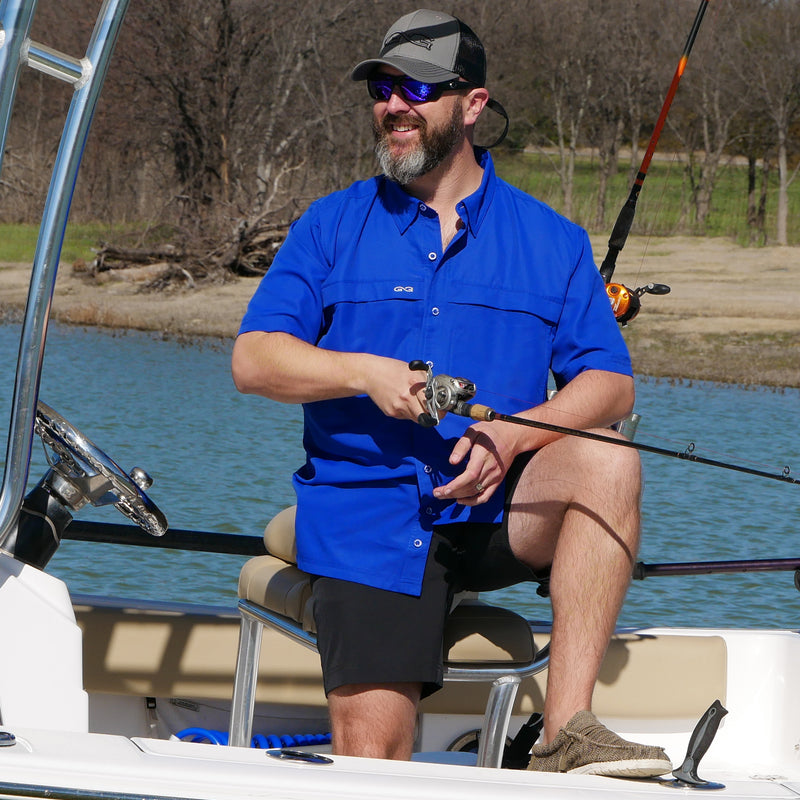 Cargue la imagen en el visor de la galería, man standing on boat wearing gameguard vaviar shorts, hydroblue microfiber shirt, and gun metal cap with caviar meshback
