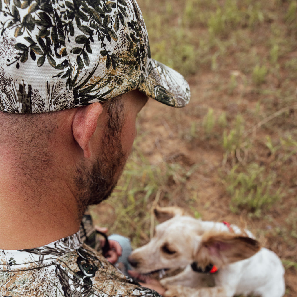 man playing with dog wearing gameguard cap