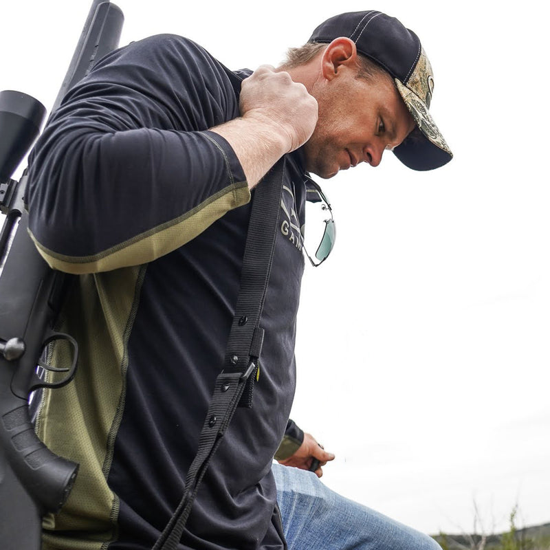 Cargue la imagen en el visor de la galería, Man walking carrying gun wearing gameguard performance hoody and gameguard fitted cap
