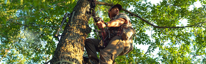 Man in a tree wearing GameGuard Digital Explorer Shirt on the hunt for a bird or perhaps a deer