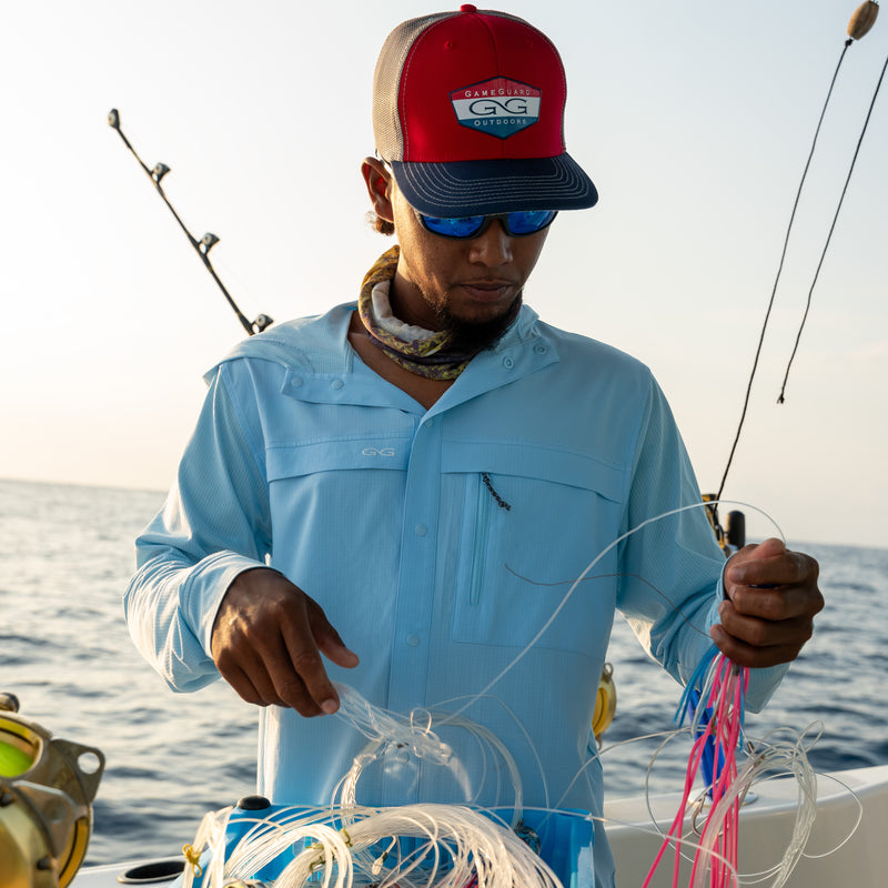 Load image into Gallery viewer, Man wearing RainWater Defender Hoody on a boat while handling fishing gear
